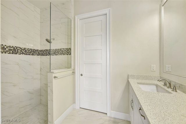 bathroom featuring tiled shower and vanity