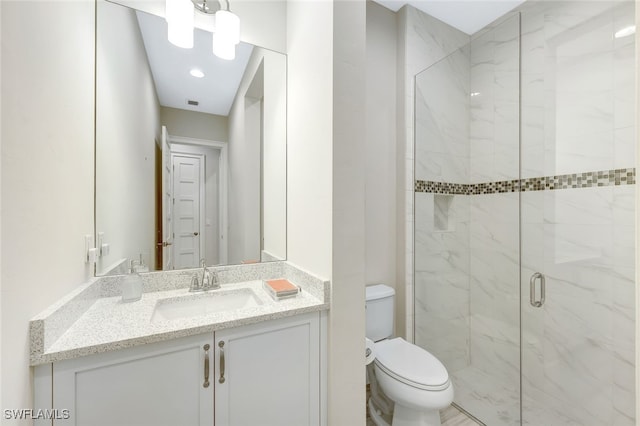 bathroom featuring vanity, toilet, and a shower with door