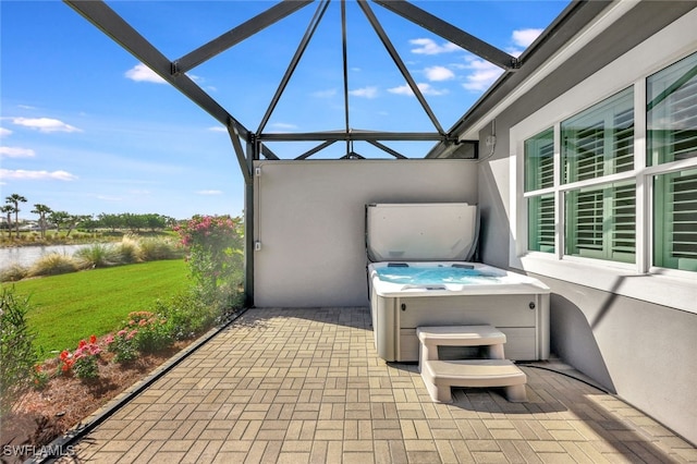 view of patio with a lanai and a hot tub