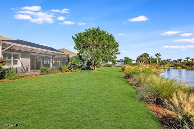 view of yard with glass enclosure and a water view