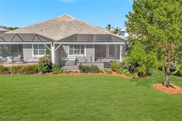 rear view of house with a jacuzzi, a yard, a patio, and a lanai