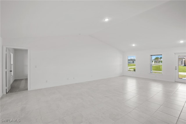 unfurnished room featuring light tile patterned floors and lofted ceiling