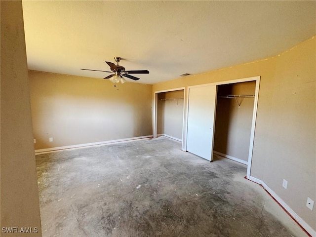 unfurnished bedroom with ceiling fan, two closets, and concrete floors