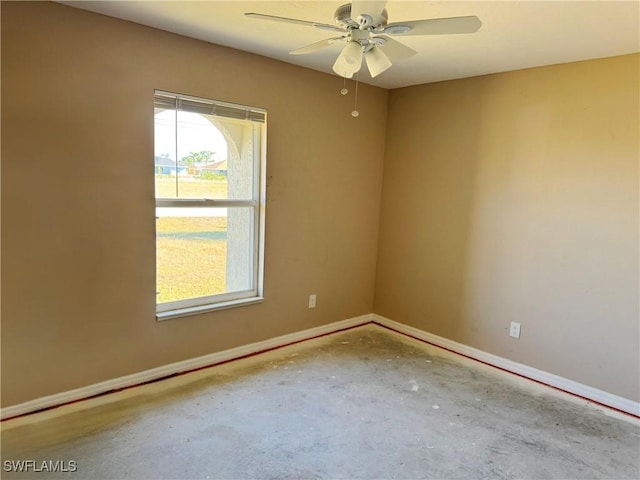 unfurnished room with ceiling fan and concrete flooring