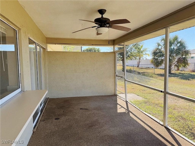 unfurnished sunroom featuring ceiling fan