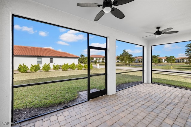 unfurnished sunroom with ceiling fan