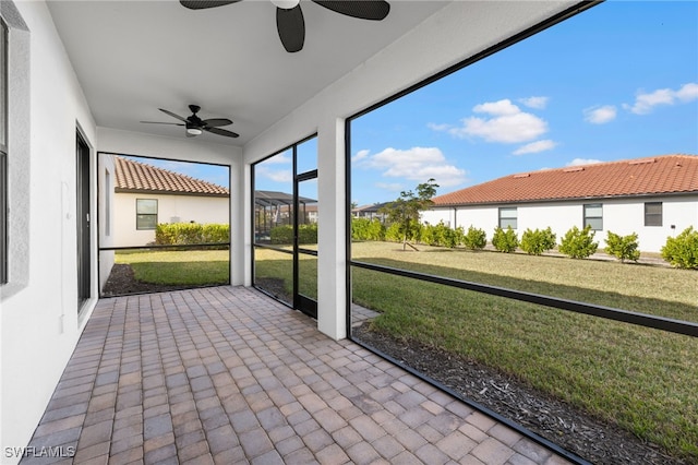 unfurnished sunroom with ceiling fan