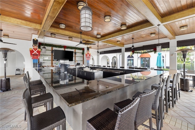 kitchen featuring beamed ceiling, decorative light fixtures, coffered ceiling, and wooden ceiling