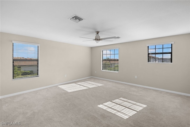 spare room with light carpet, plenty of natural light, and ceiling fan