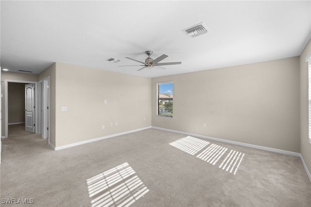 empty room featuring ceiling fan and light colored carpet