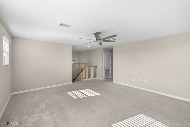 empty room featuring ceiling fan and light colored carpet