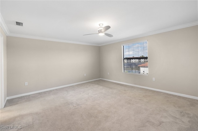 carpeted spare room with ceiling fan and crown molding