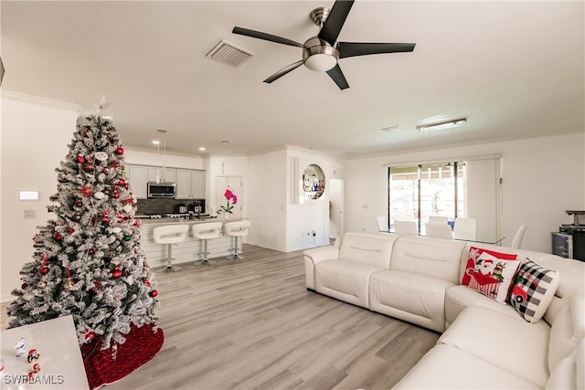 living room featuring ceiling fan and light hardwood / wood-style floors