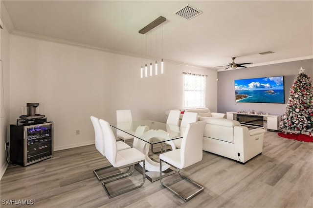 dining area with ceiling fan, hardwood / wood-style floors, and ornamental molding