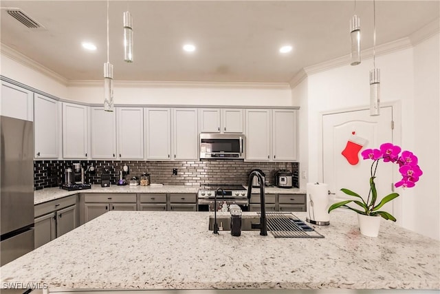 kitchen featuring stainless steel appliances, hanging light fixtures, crown molding, and sink