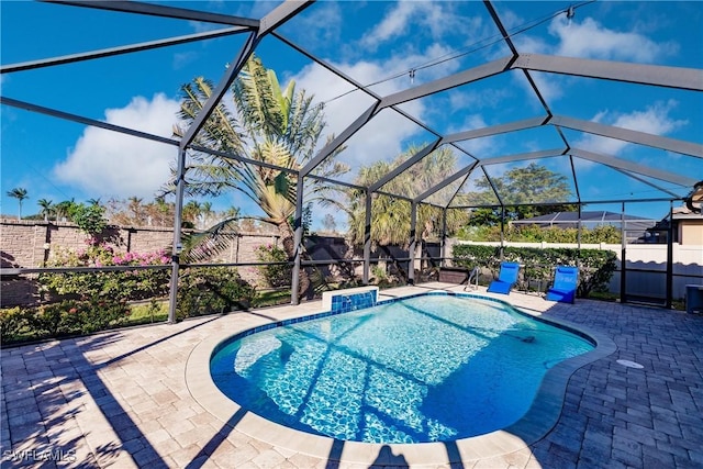 view of swimming pool featuring a patio and a lanai