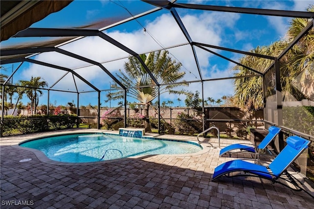 view of swimming pool with glass enclosure, a patio area, and pool water feature