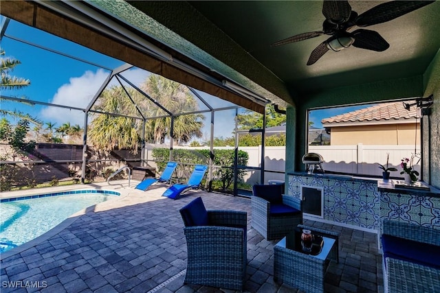 view of patio with outdoor lounge area, ceiling fan, a lanai, and a fenced in pool