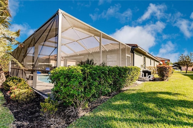 view of home's exterior with a lanai and a yard