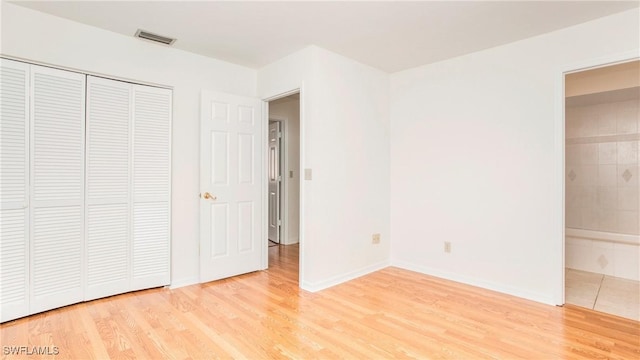 unfurnished bedroom with hardwood / wood-style floors and a closet