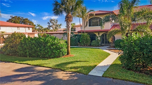 mediterranean / spanish home with a front yard