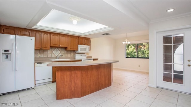 kitchen with a center island, a chandelier, decorative light fixtures, white appliances, and decorative backsplash