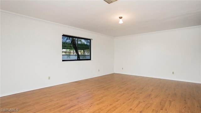 spare room featuring crown molding and light hardwood / wood-style flooring