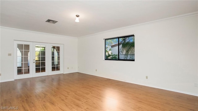 spare room with french doors, a wealth of natural light, ornamental molding, and hardwood / wood-style floors