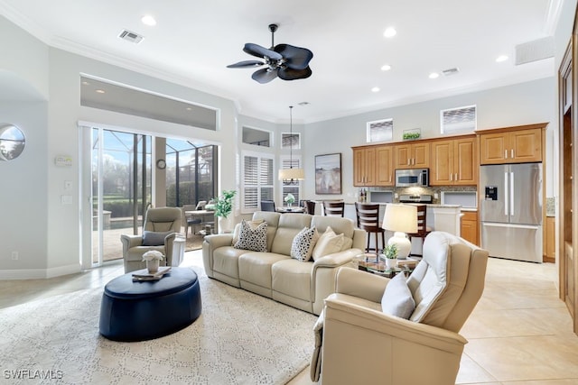 living room featuring ceiling fan, ornamental molding, and light tile patterned flooring