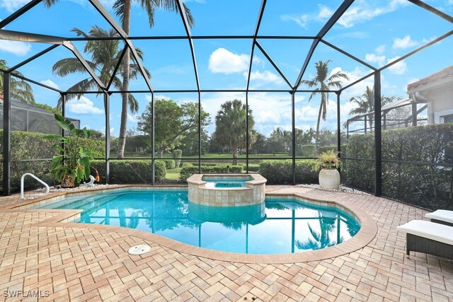 view of pool with an in ground hot tub, glass enclosure, and a patio area