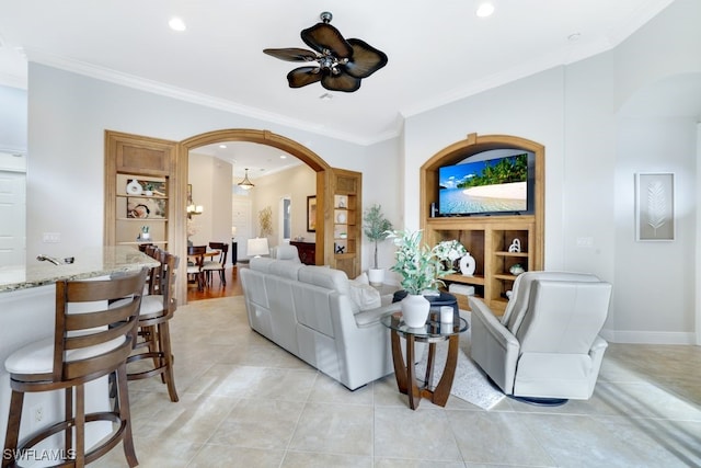 living room with ceiling fan, crown molding, and light tile patterned floors