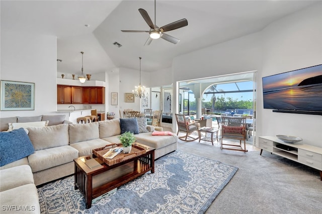 living room featuring ceiling fan with notable chandelier, high vaulted ceiling, and carpet