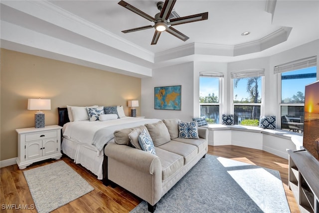 bedroom featuring crown molding, ceiling fan, a tray ceiling, and hardwood / wood-style flooring