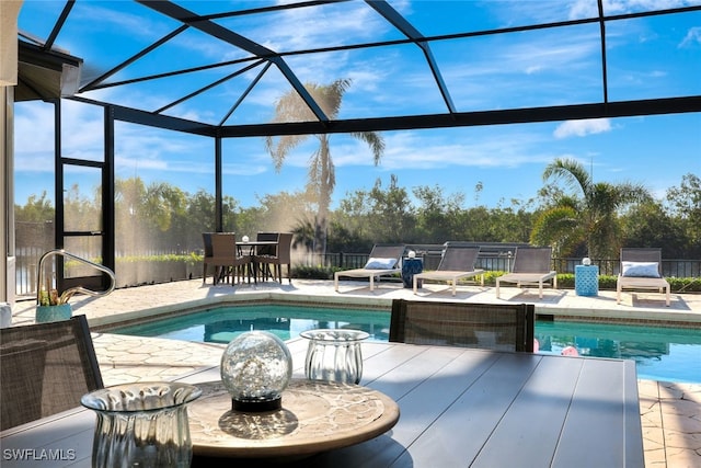 view of swimming pool with glass enclosure and a patio