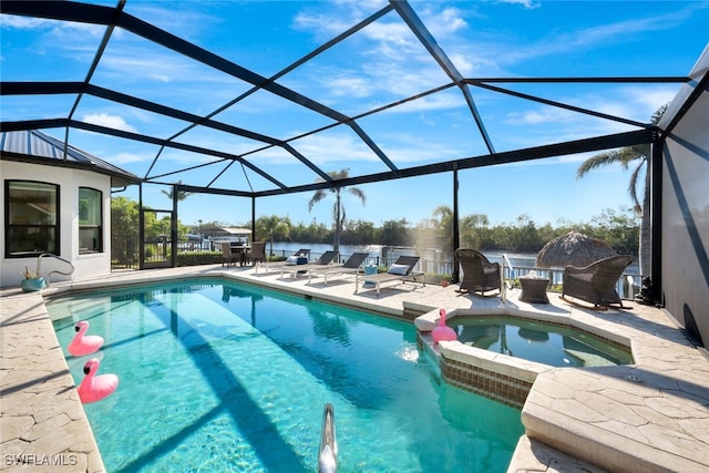 view of swimming pool with an in ground hot tub, a water view, glass enclosure, and a patio