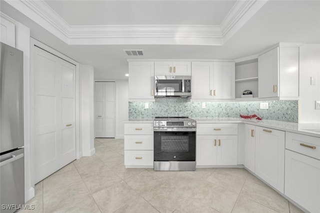 kitchen with white cabinets, a raised ceiling, backsplash, and appliances with stainless steel finishes