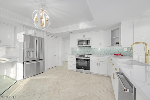 kitchen featuring white cabinetry, sink, light stone counters, decorative backsplash, and appliances with stainless steel finishes