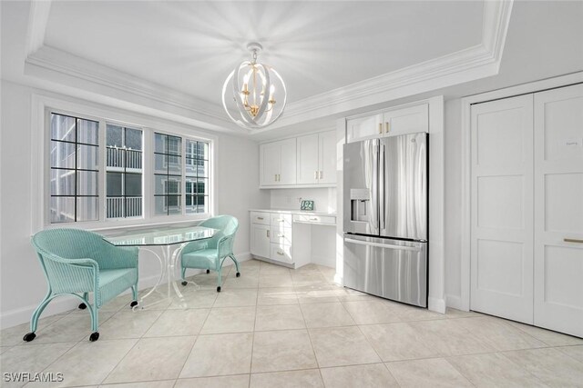 dining area featuring a raised ceiling, light tile patterned floors, a chandelier, and ornamental molding