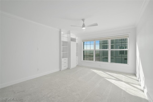 empty room with carpet, ceiling fan, and crown molding