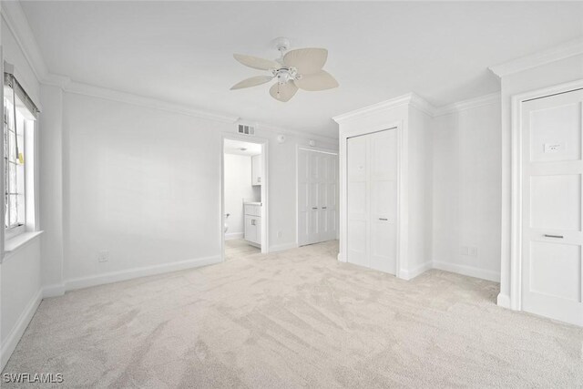 unfurnished bedroom with connected bathroom, crown molding, ceiling fan, and light carpet