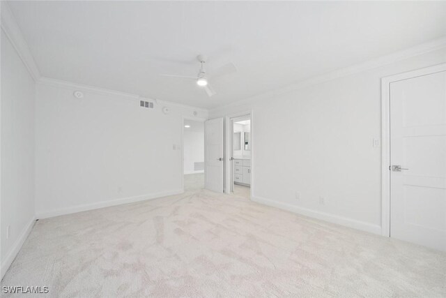 carpeted spare room with ceiling fan and ornamental molding