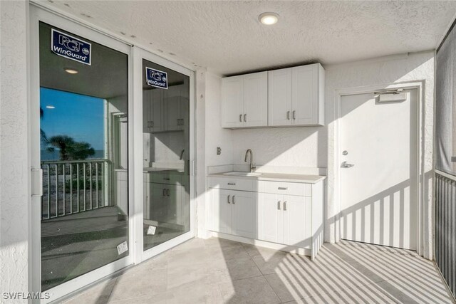 interior space with a textured ceiling and sink