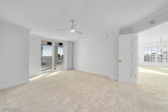 carpeted empty room featuring ceiling fan with notable chandelier and ornamental molding