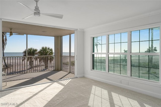 unfurnished sunroom featuring ceiling fan and a water view