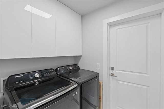 laundry area with washer and clothes dryer and cabinets