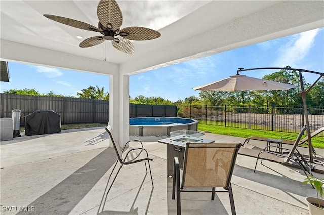 view of patio / terrace featuring a bar, a fenced in pool, and ceiling fan