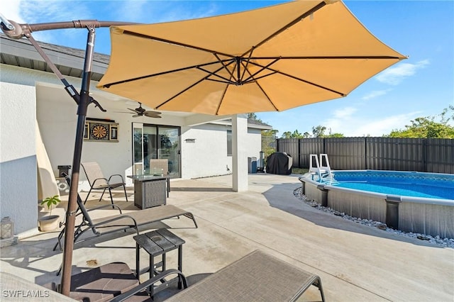 view of patio with a fenced in pool and ceiling fan