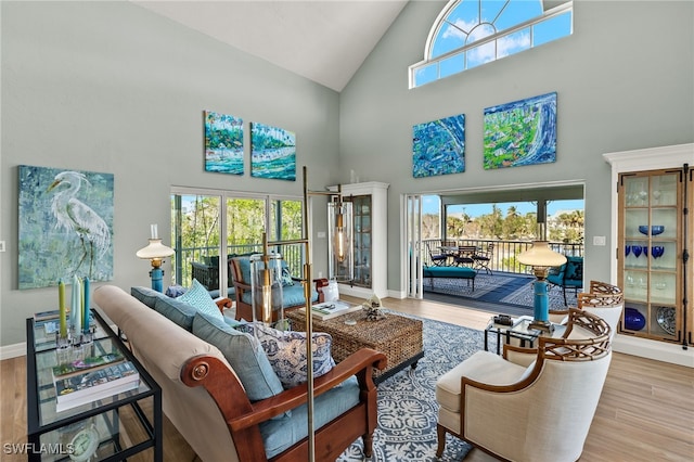 living room with hardwood / wood-style floors and a towering ceiling