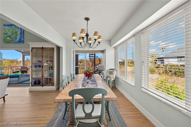 dining space with a notable chandelier and light wood-type flooring