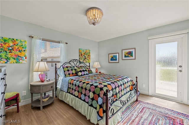 bedroom with access to exterior and light wood-type flooring